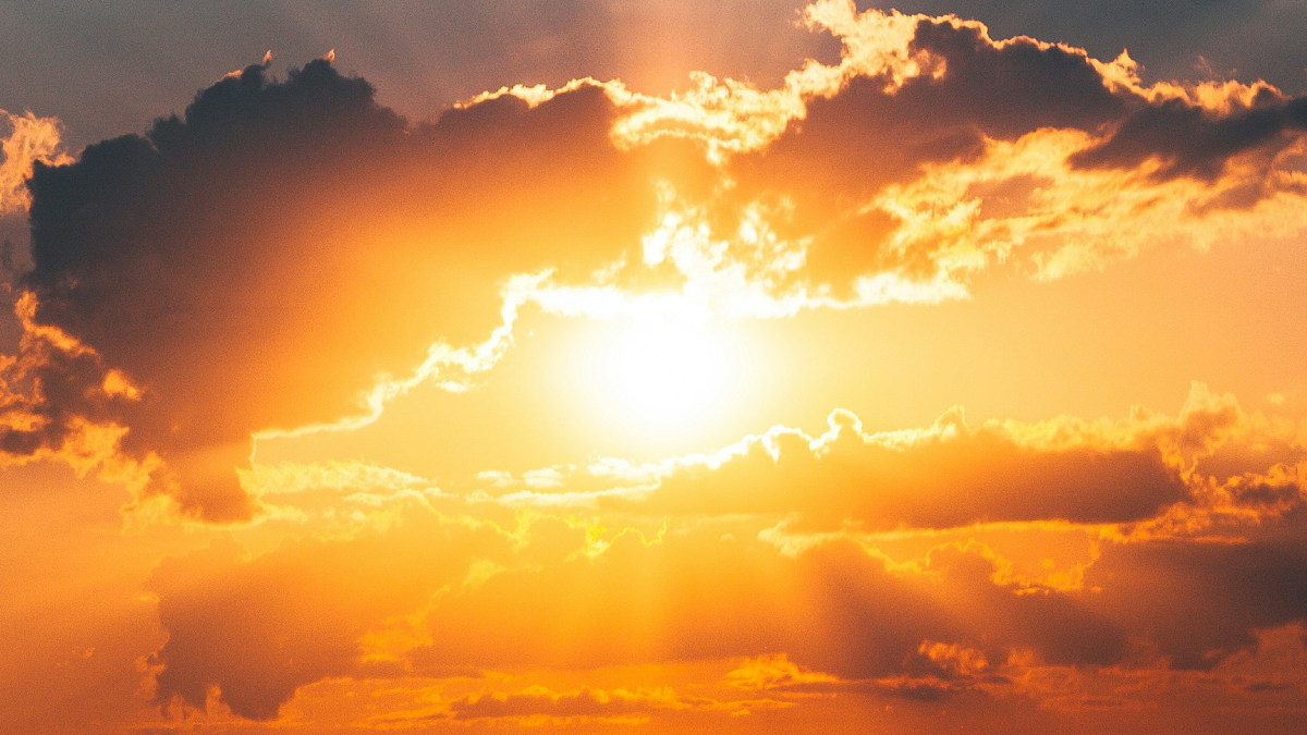 A photograph of the sun behind clouds.